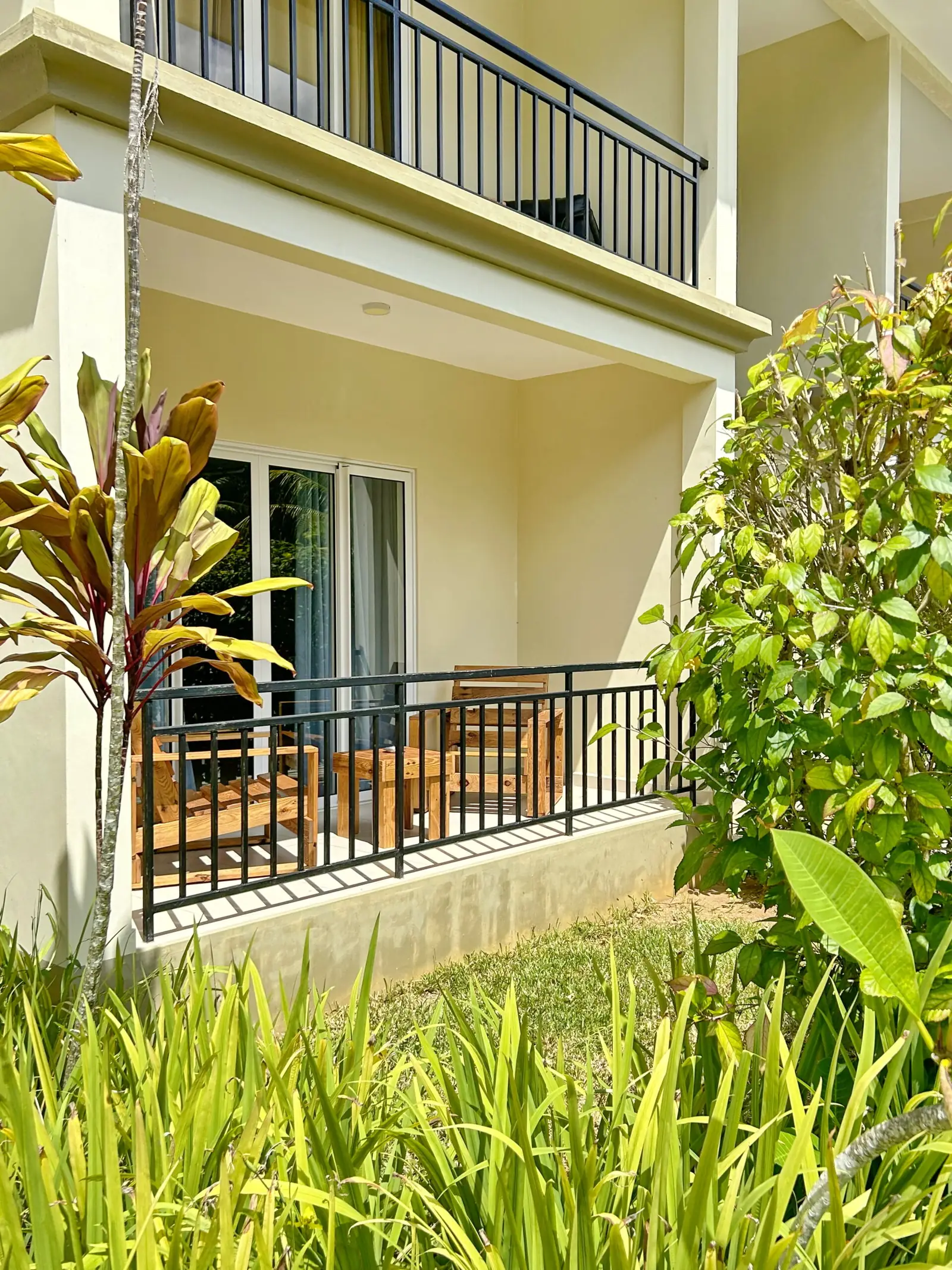 Ground-floor terrace of an apartment framed by tropical plants